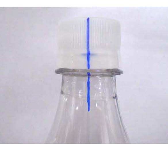 Vertical blue line drawn on the cap, tamper-evidence band and bottle neck